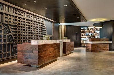 A hotel lobby with two wooden desks and a marble counter.