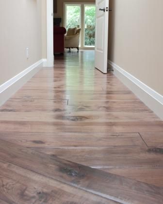 A hallway with hardwood floors leading to a living room