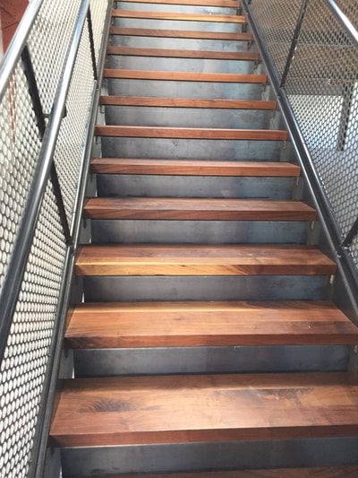 A set of stairs with wooden steps and a metal railing.