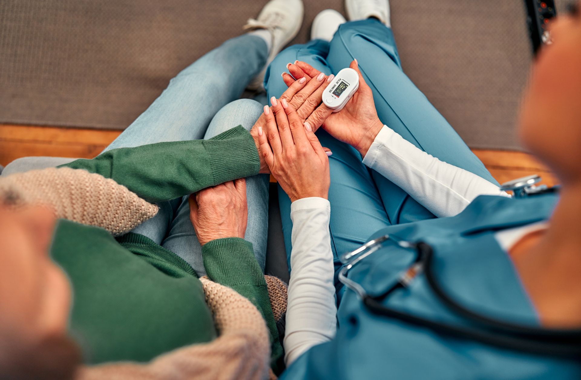 Nurse taking patient's pulse with a pulse oximeter.