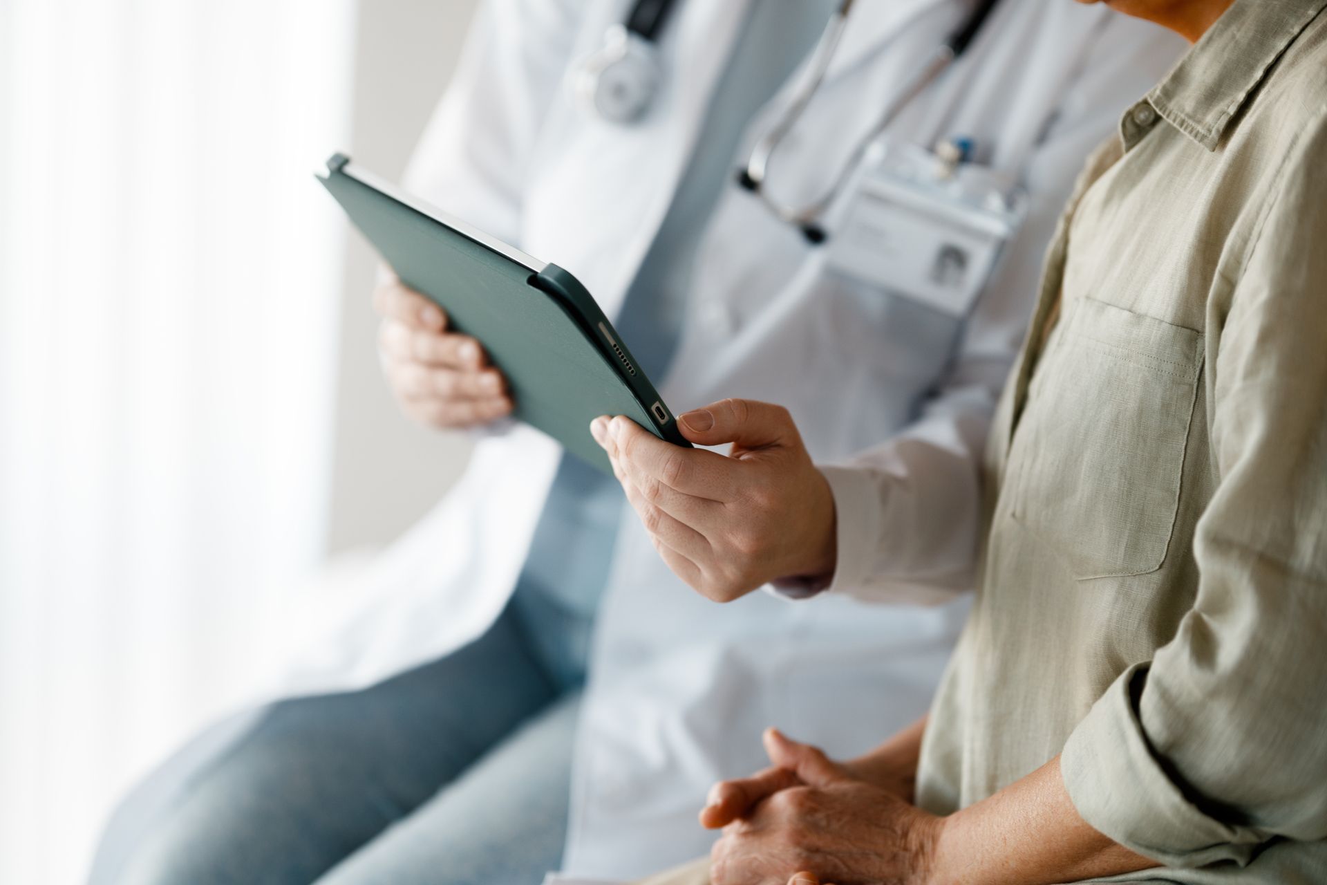 Doctor in white coat reviewing medical chart with patient.