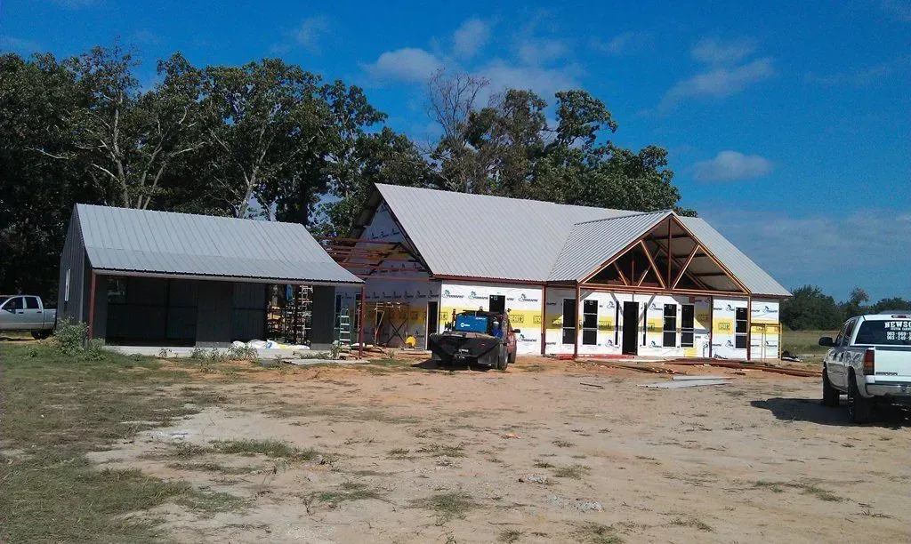 A truck is parked in front of a house under construction.
