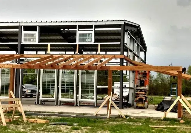 A building under construction with a wooden structure in front of it