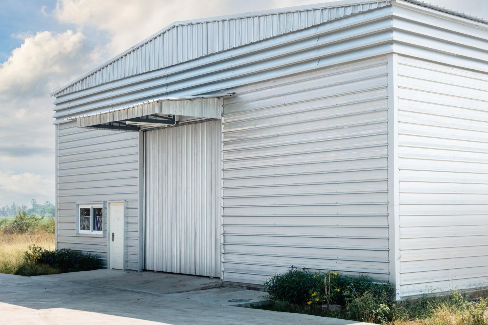 A large white building with a sliding door and a window.
