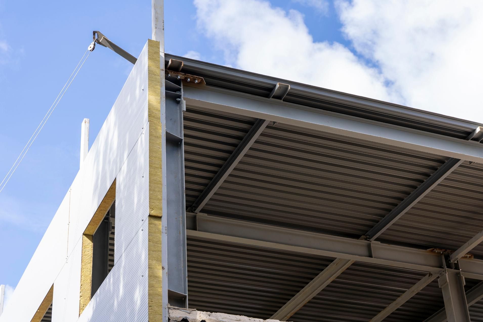 A building under construction with a blue sky in the background.