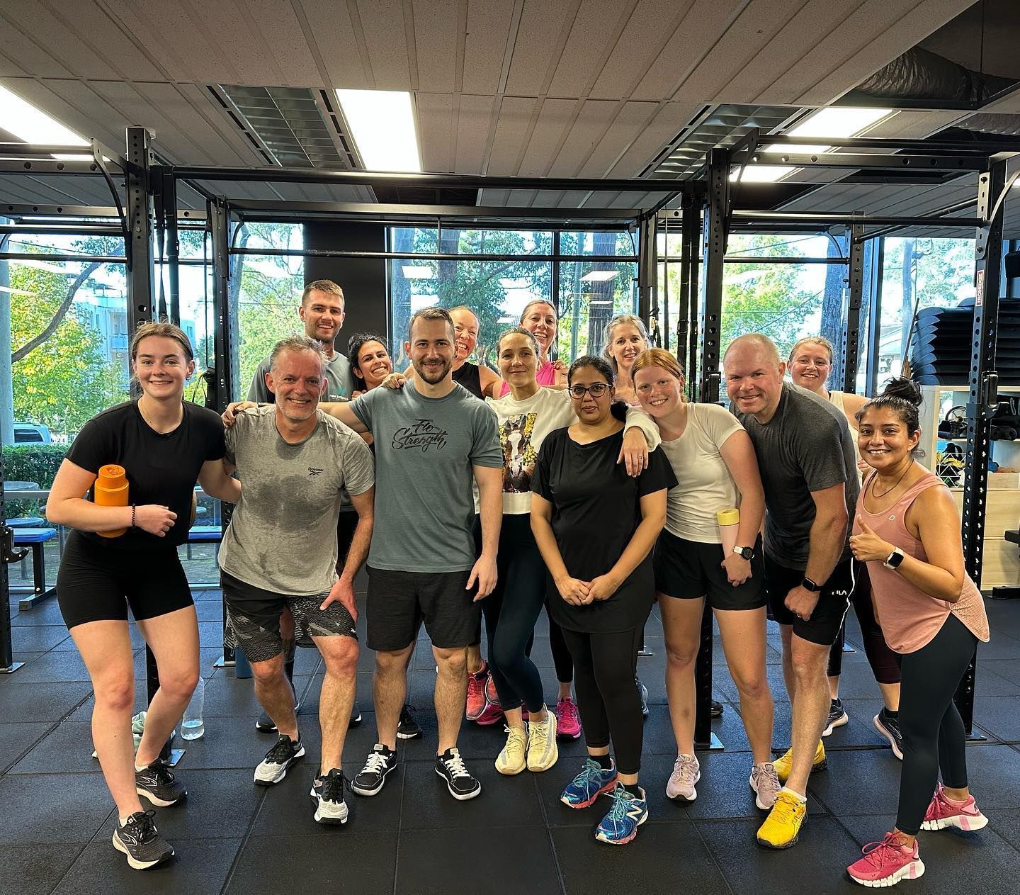 A group of people are posing for a picture in a gym.