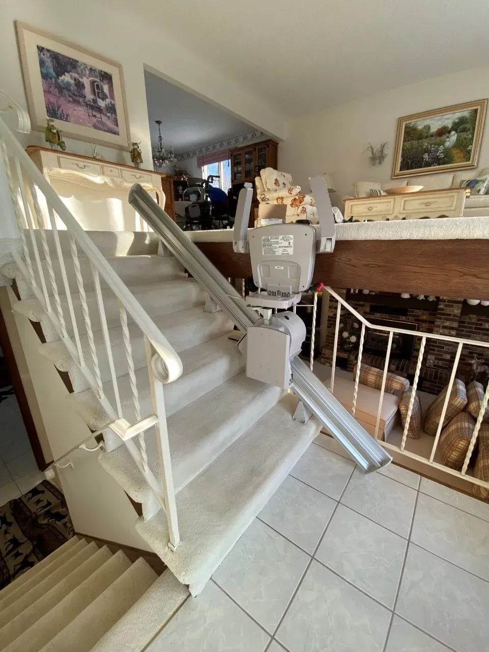 Indoor staircase with white railing, carpeted steps, and tiled floor beside a dining area