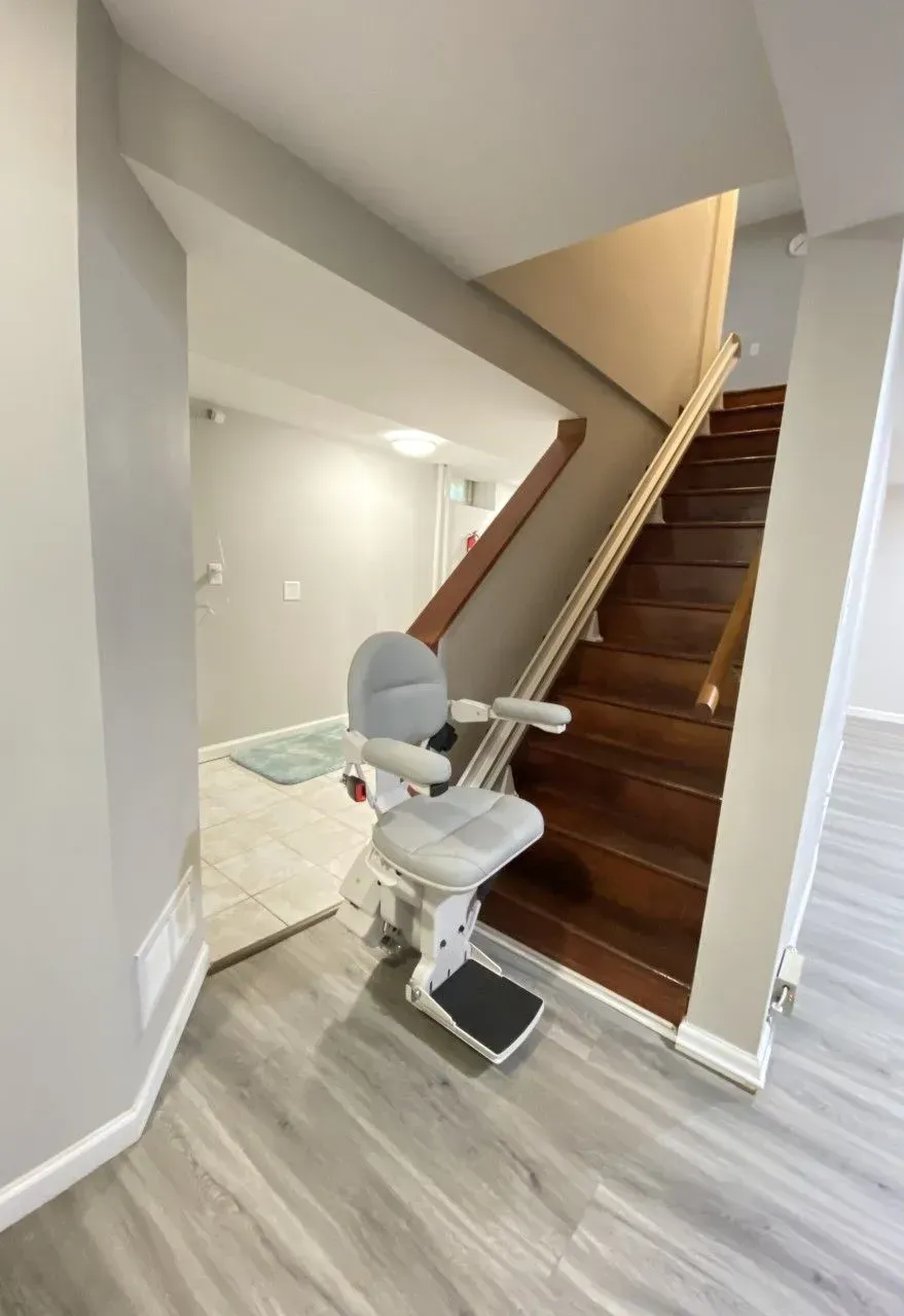 Stairlift installed on a wooden staircase in a bright home interior.