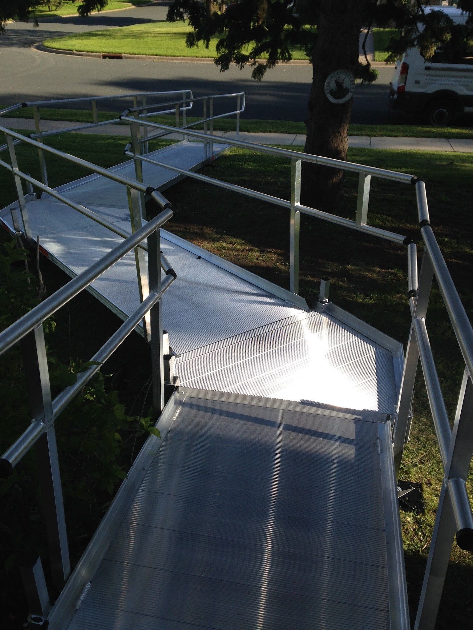 Metal accessibility ramp with railings in a sunny outdoor park area