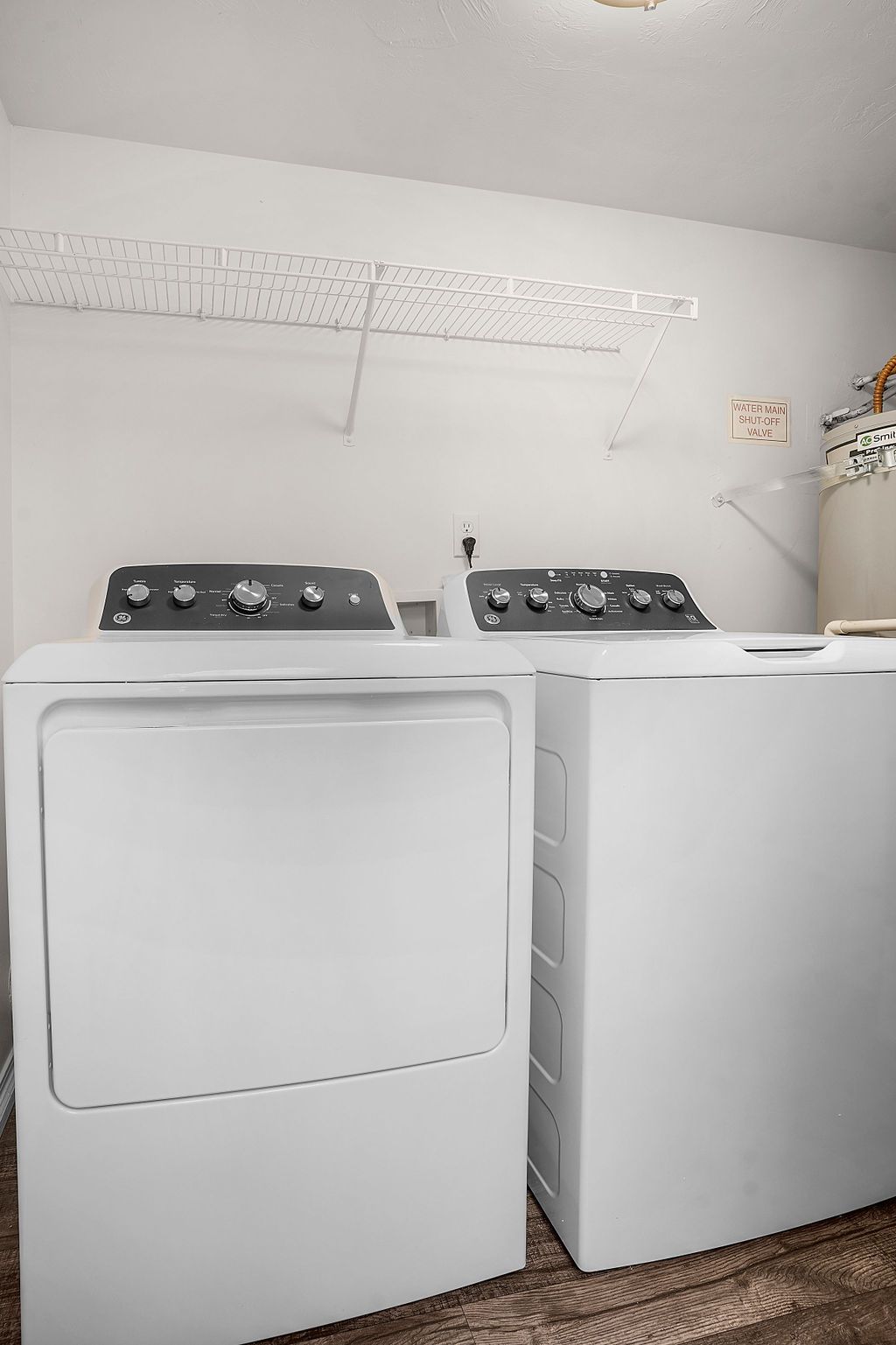 White washer and dryer in a laundry room with a sloped ceiling at Creekside Village apartments in Sandy, UT.