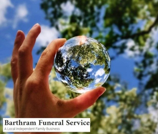 Hand holding a glass orb reflecting a blue sky and trees, with Bartham Funeral Service logo at bottom left