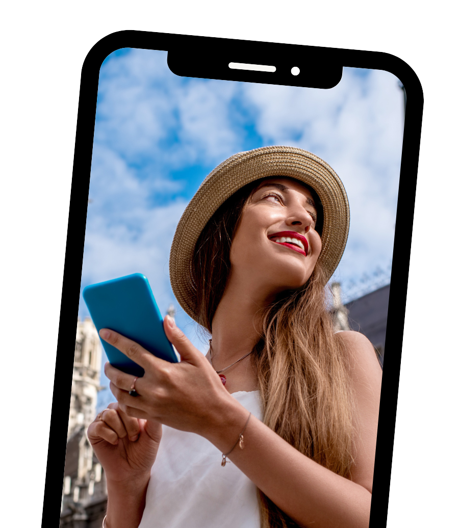 Woman in a straw hat smiling while holding a blue phone against a city skyline