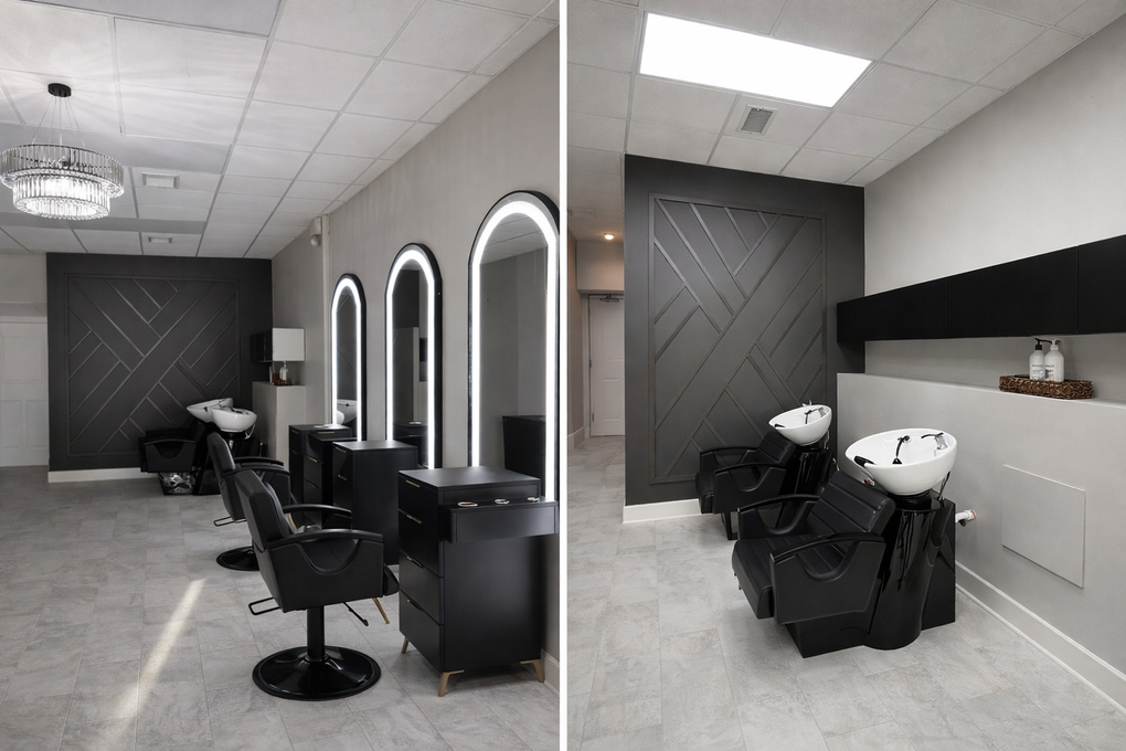 Modern hair salon with black styling chairs, mirrors, wash sinks, and gray walls
