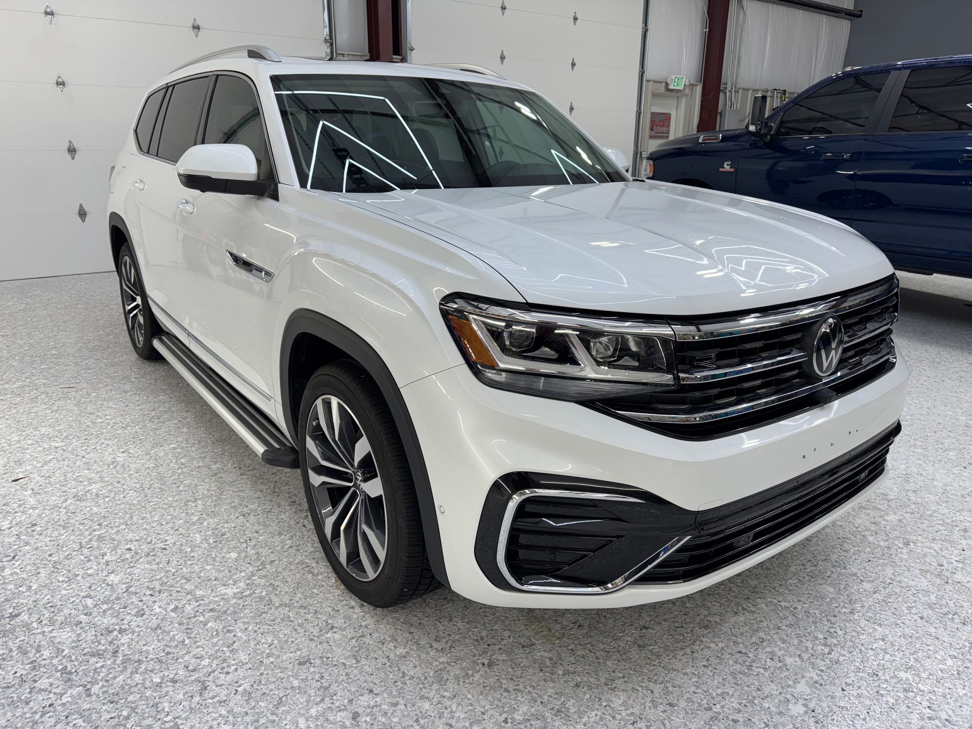 White SUV in a showroom, front three-quarter view, with black trim and silver wheels