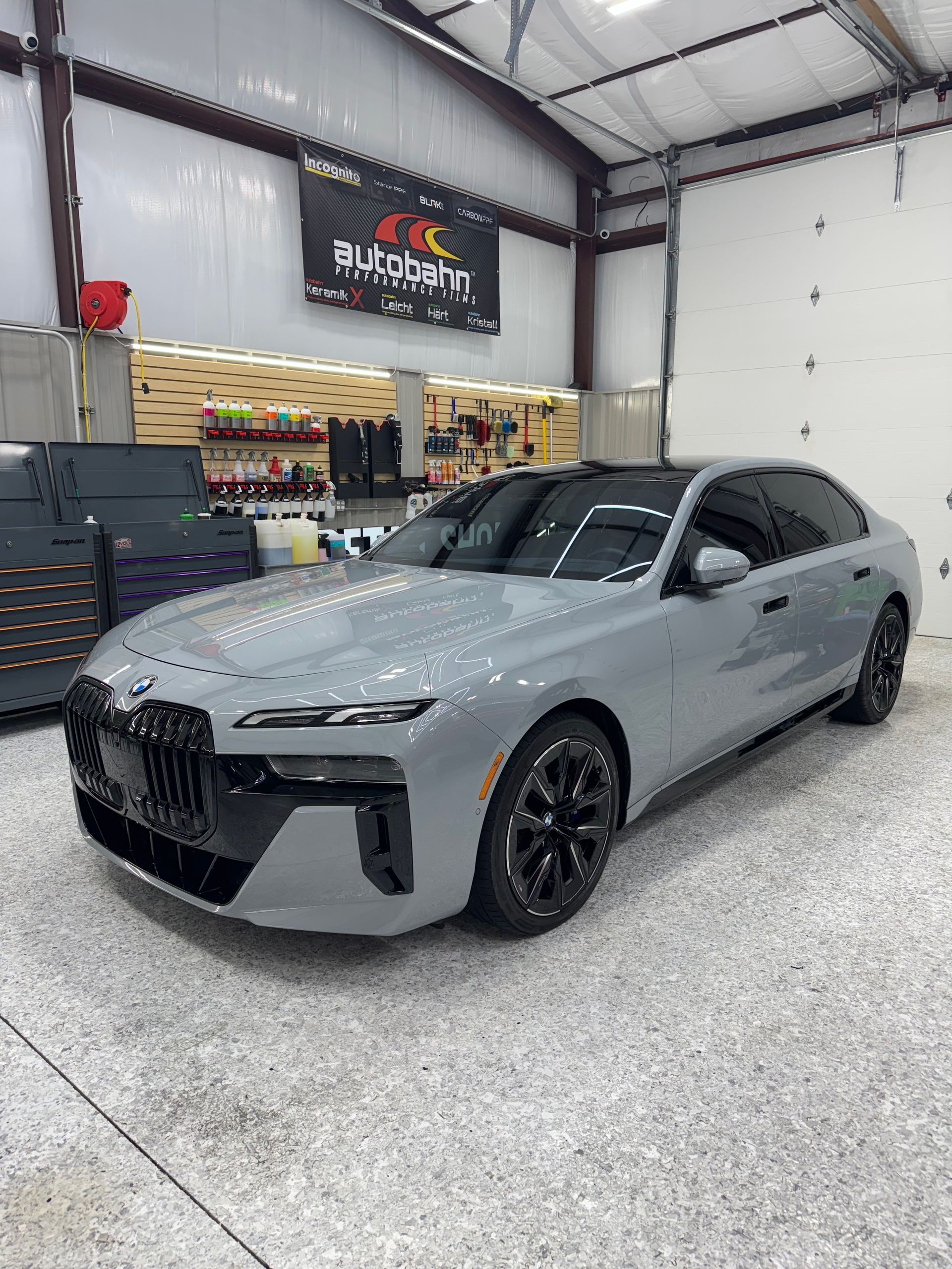 Gray BMW sedan in a garage, black accents.