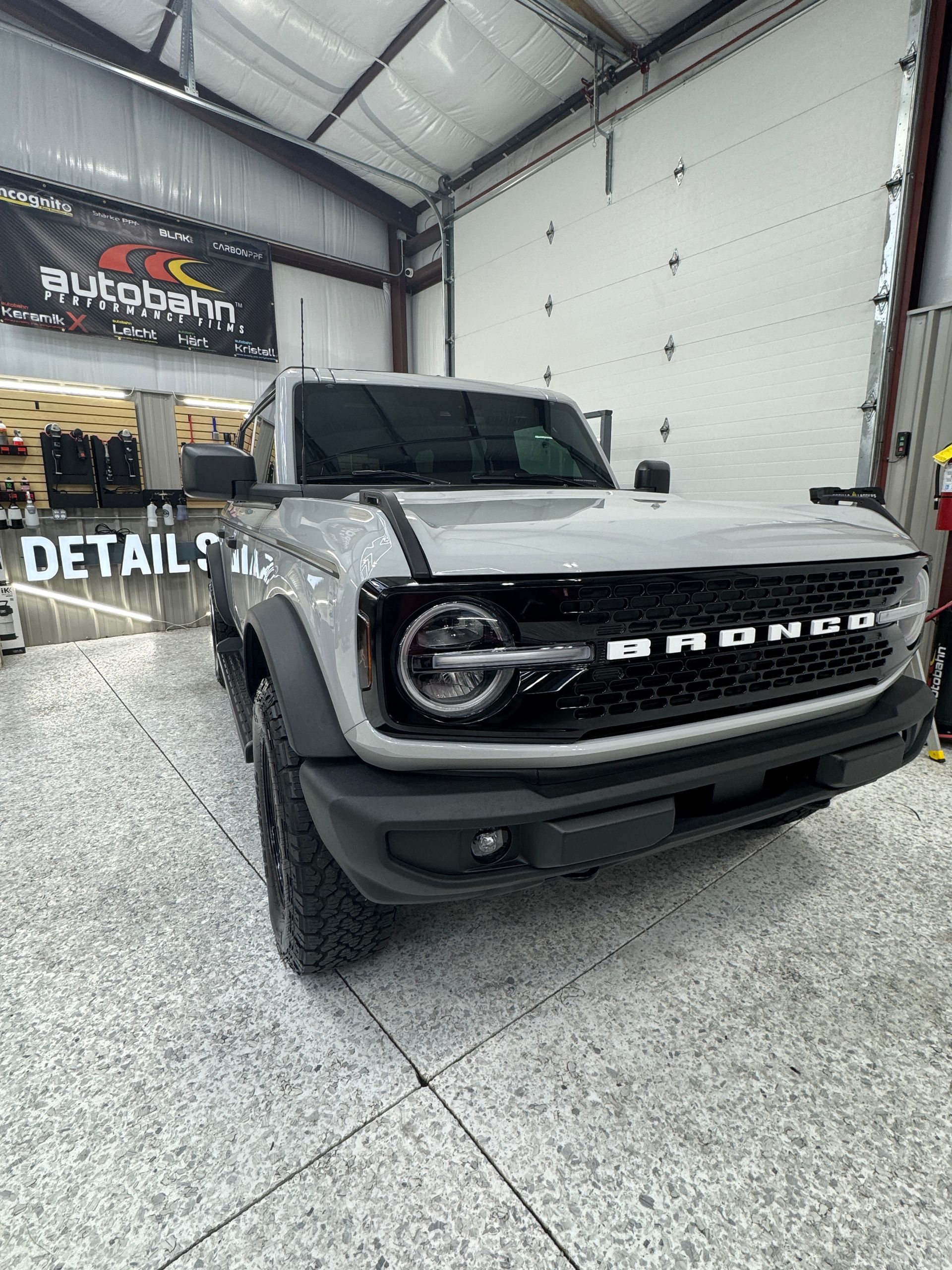 Gray Ford Bronco in a detailing shop, front view indoors