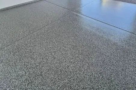 Gray speckled concrete floor with a glossy wet patch near the top right corner