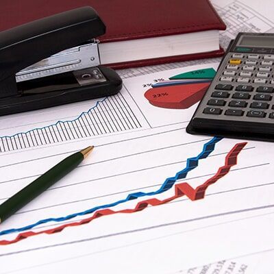 A Stapler Calculator And Pen On Top Of A Graph - Individual & Business Taxation & Financial Planning in Mackay
