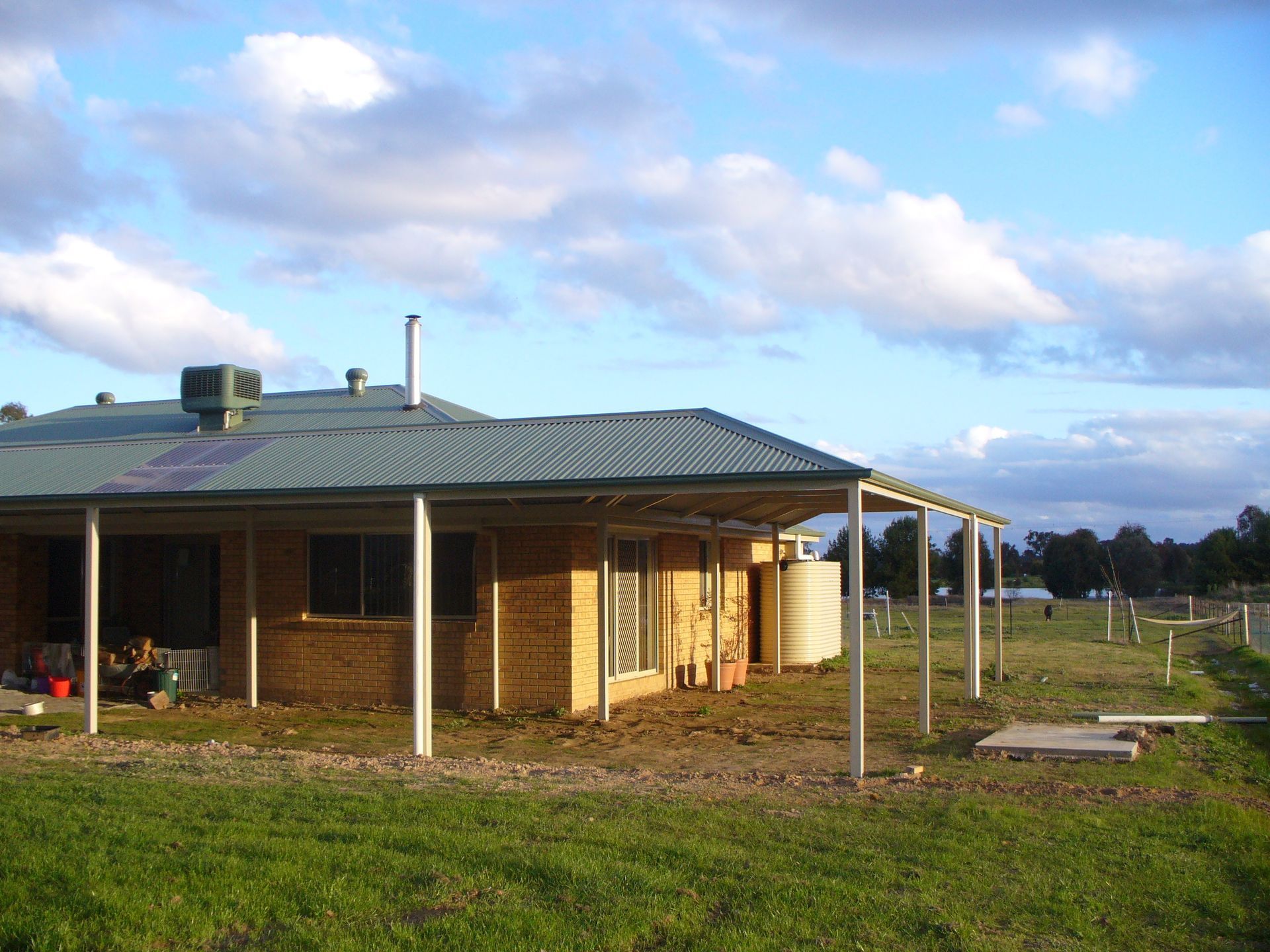 A Single-story Brick House With a Corrugated Metal Roof and a Large — The Gazebo and Shade Centre in Jindera, NSW