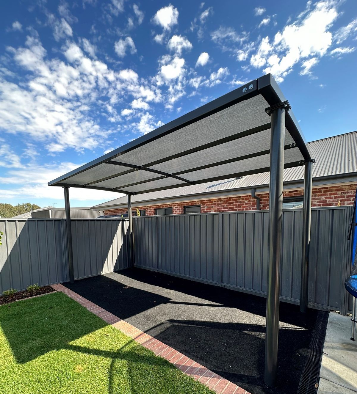 Black Pergola With a Mesh Roof in a Backyard — The Gazebo and Shade Centre in Jindera, NSW
