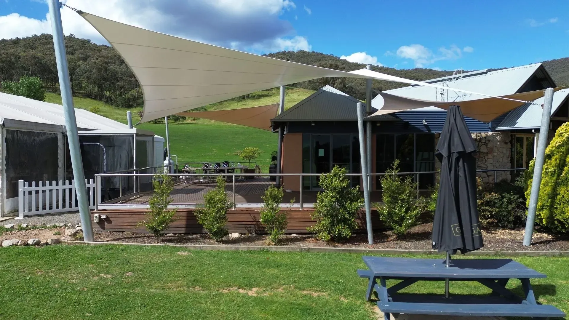 Outdoor Patio With Shade Sails Over a Wooden Deck — The Gazebo and Shade Centre in Jindera, NSW