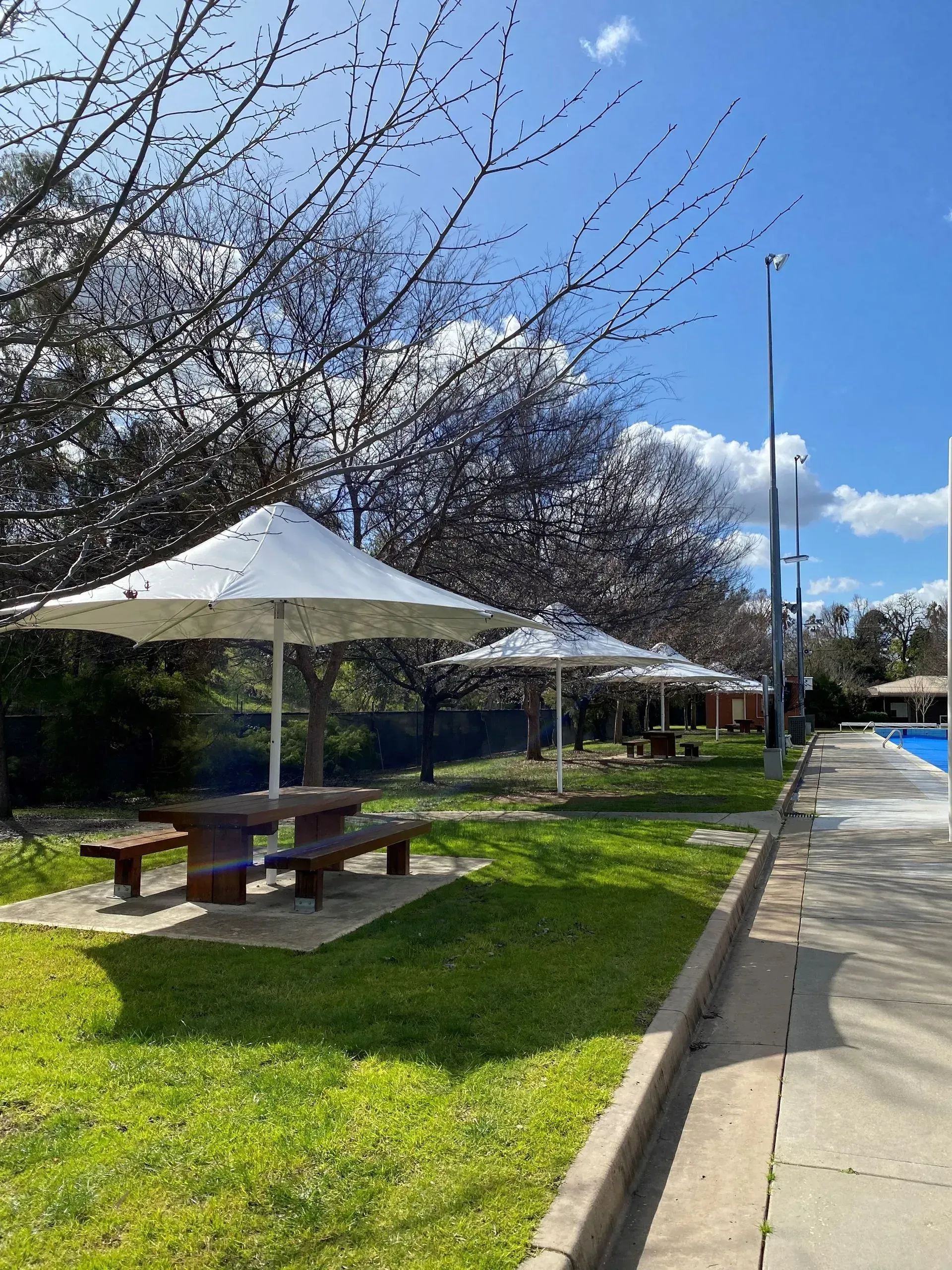 Picnic Tables With White Umbrellas on a Grassy Area — The Gazebo and Shade Centre in Jindera, NSW