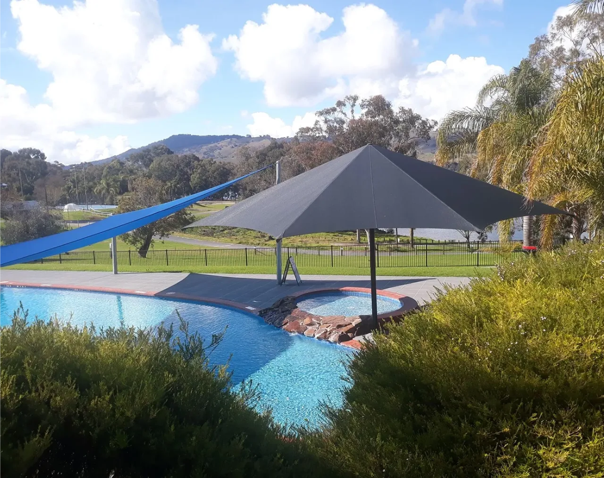 A Grey Fixed Centre Pole Umbrella Over a Spa and Pool — The Gazebo and Shade Centre in Jindera, NSW