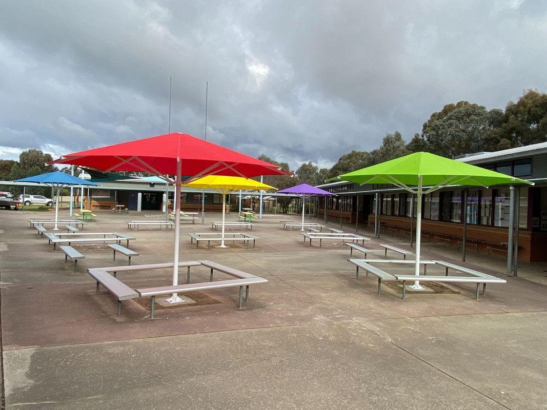 A Courtyard With Several Colourful Square Outdoor Umbrellas — The Gazebo and Shade Centre in Jindera, NSW