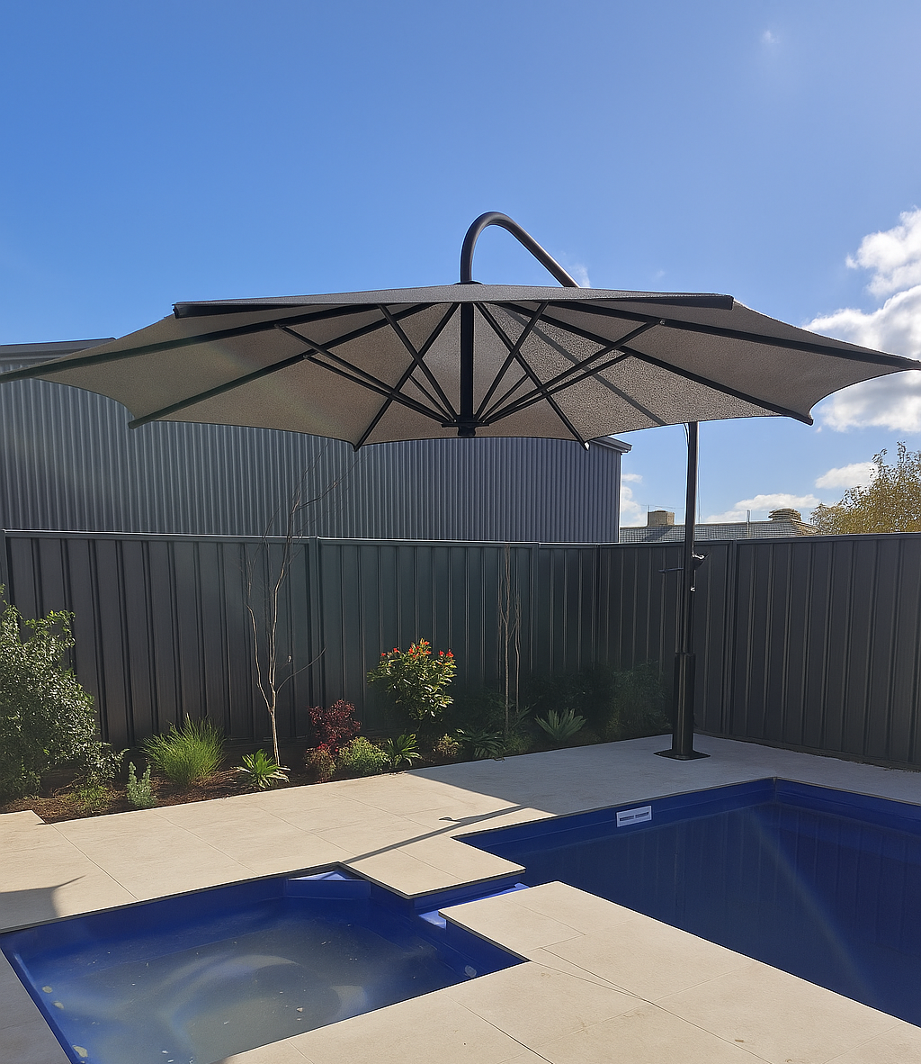 Outdoor cafe seating with grey chairs arranged under three large black umbrellas on a sunny, grassy lawn — The Gazebo and Shade Centre in Jindera, NSW