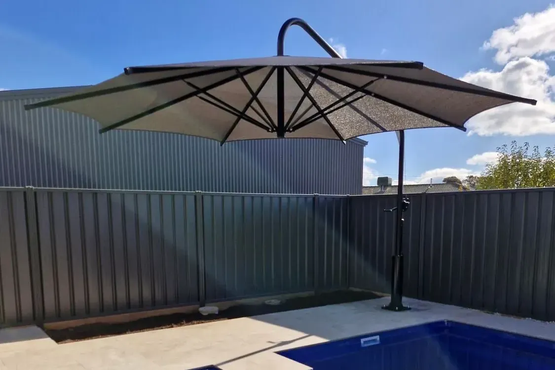 A Shade Umbrella Over A Backyard Pool — The Gazebo and Shade Centre in Bright, VIC