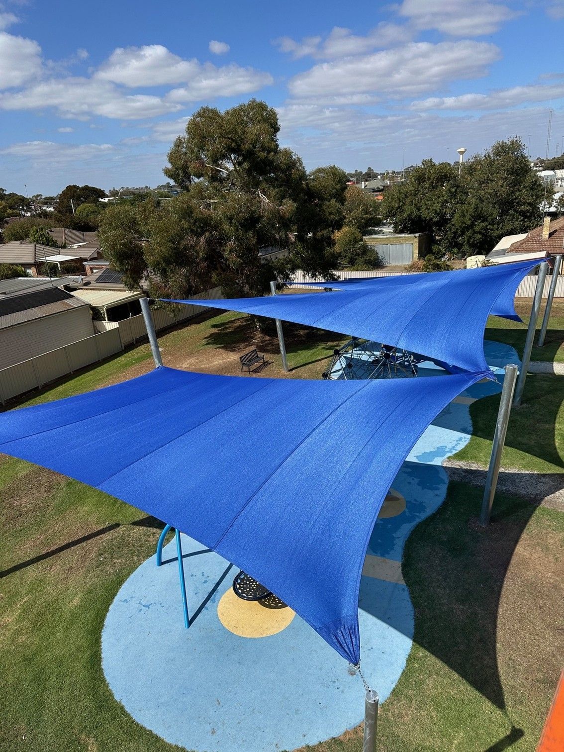 Blue shade sails over a backyard patio and lawn on a sunny day  — The Gazebo and Shade Centre in Yarrawonga, VIC