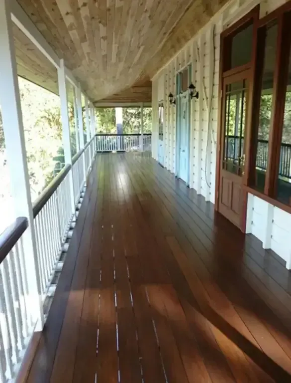A Long Hallway With A Wooden Floor And White Railing — Dale Dow Floor Sanding In Kirwan, QLD