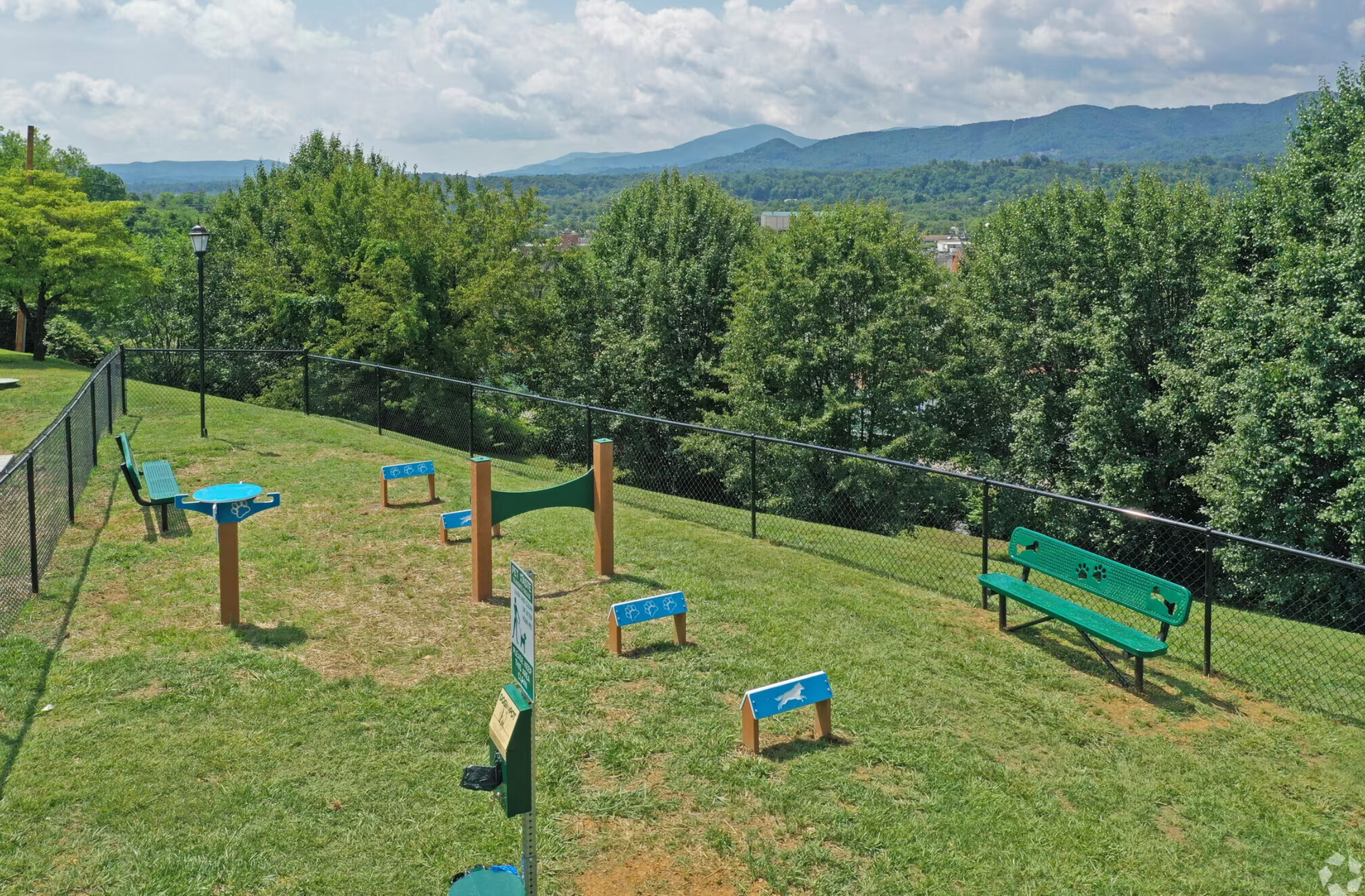 An aerial view of a dog park with mountains in the background.