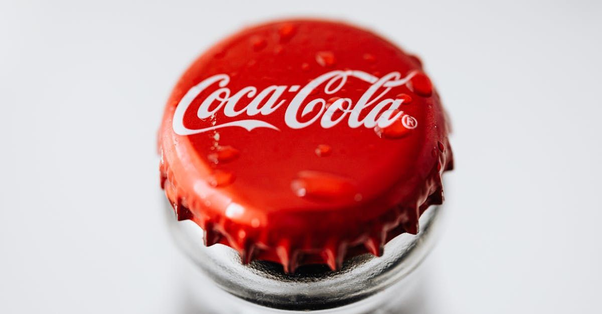 Close-up of a red Coca-Cola bottle cap with white logo and condensation droplets