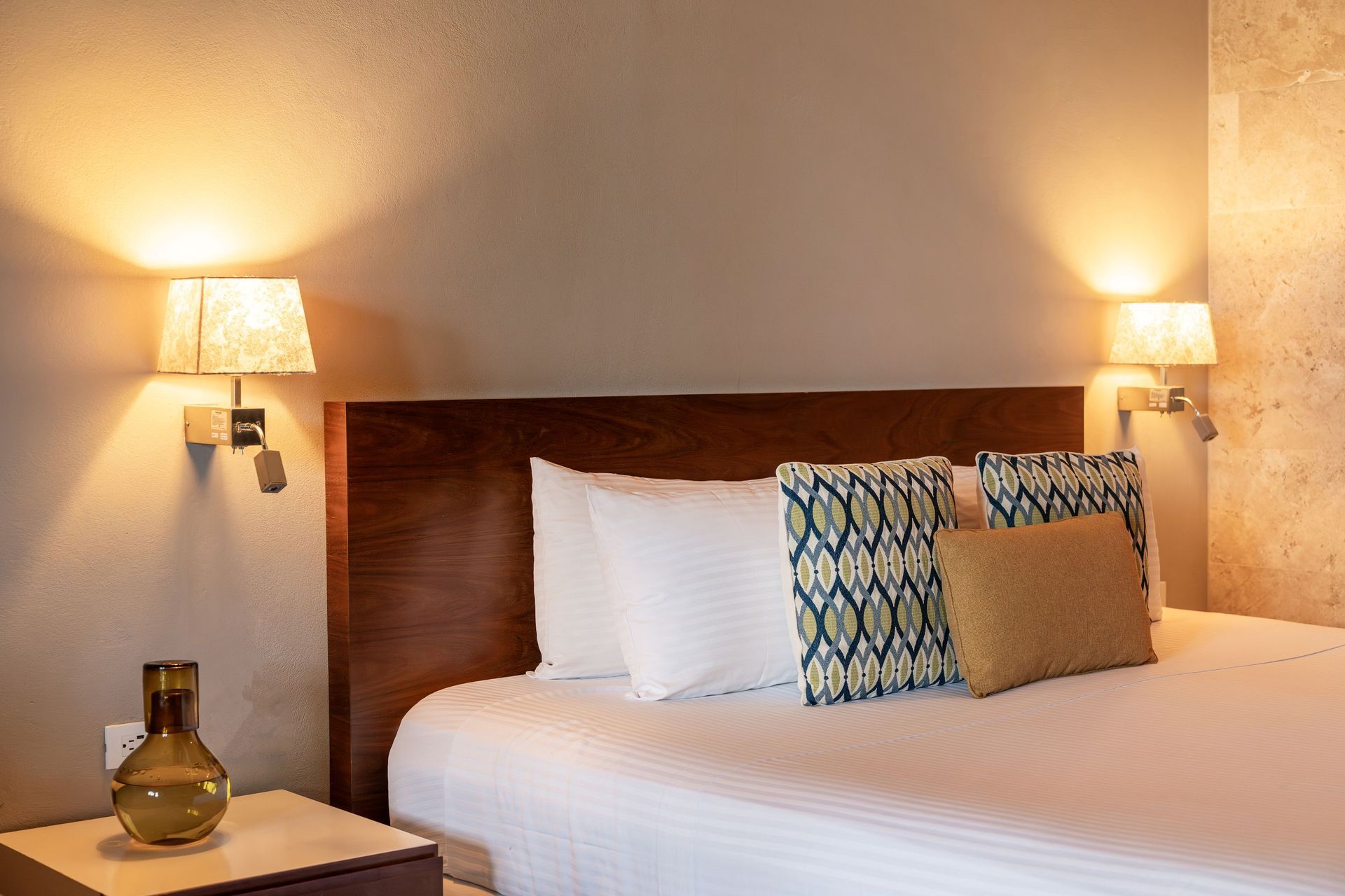 Bedroom with a bed, pillows, lamps, and a nightstand.