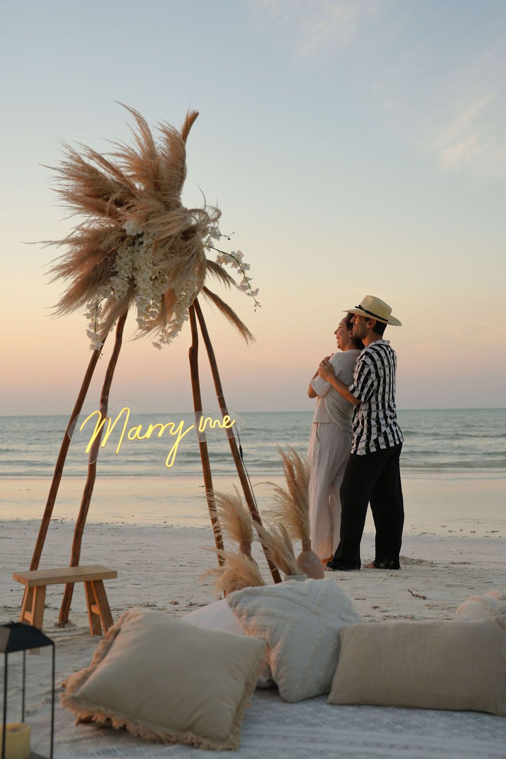 Couple hugging on beach at sunset near