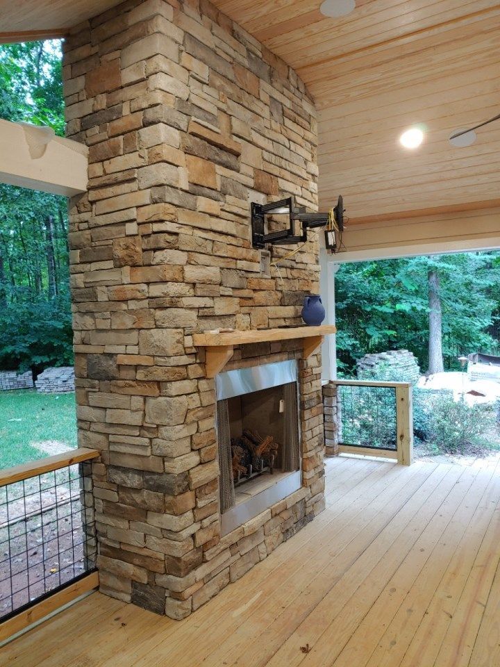 Stone patio with steps, pergola, and brick apartment building with arched entryways