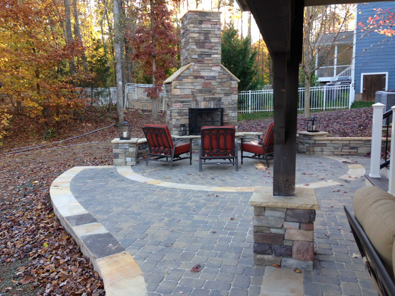 Stone patio with steps, pergola, and brick apartment building with arched entryways