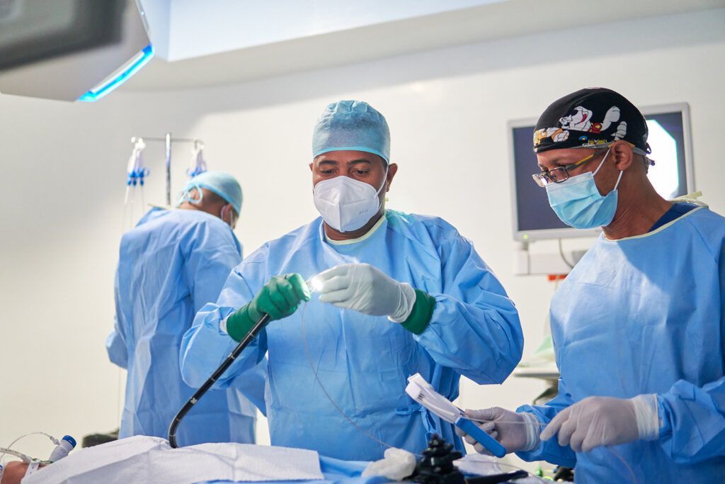 A group of surgeons are operating on a patient in an operating room.