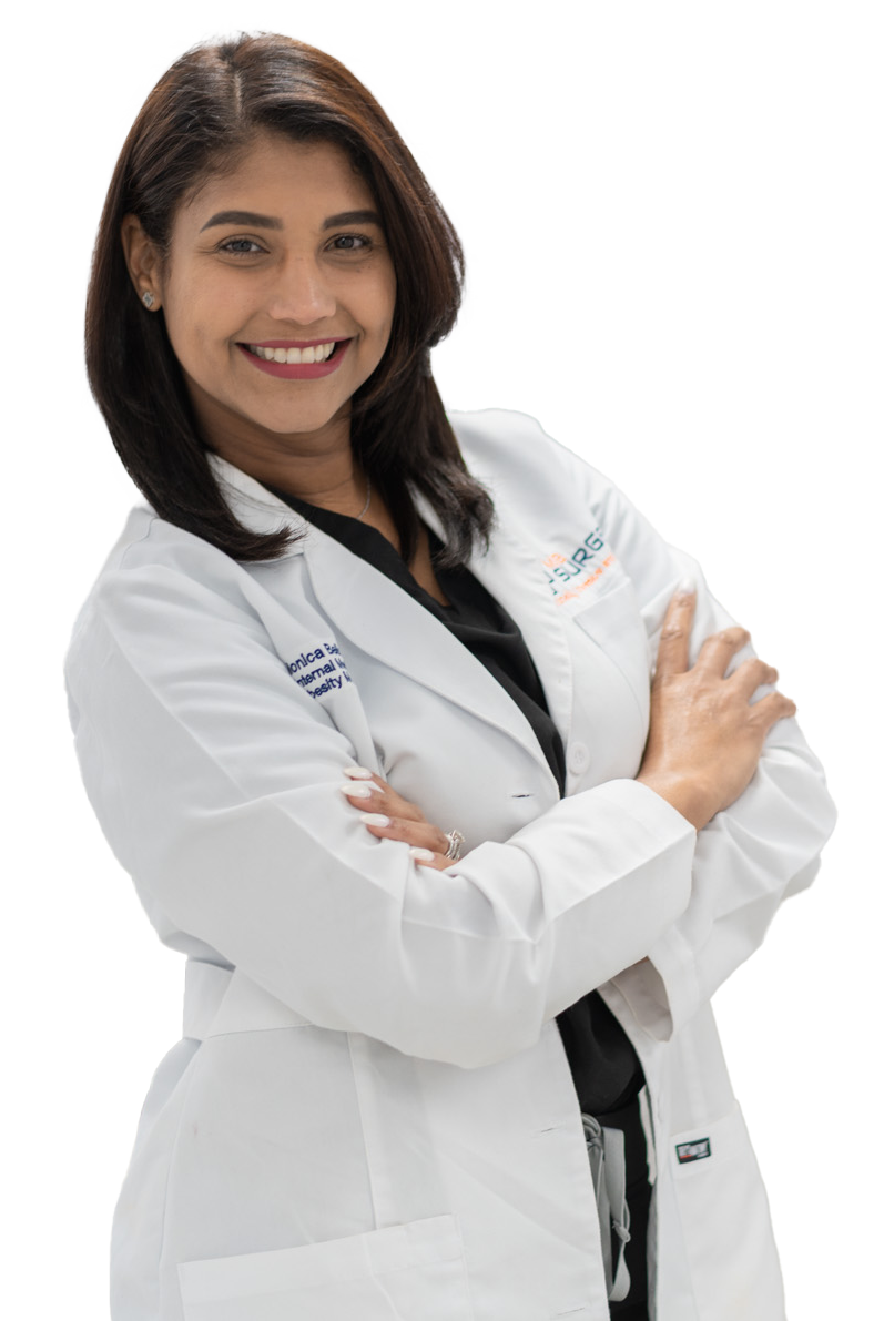 A woman in a white lab coat is smiling with her arms crossed.