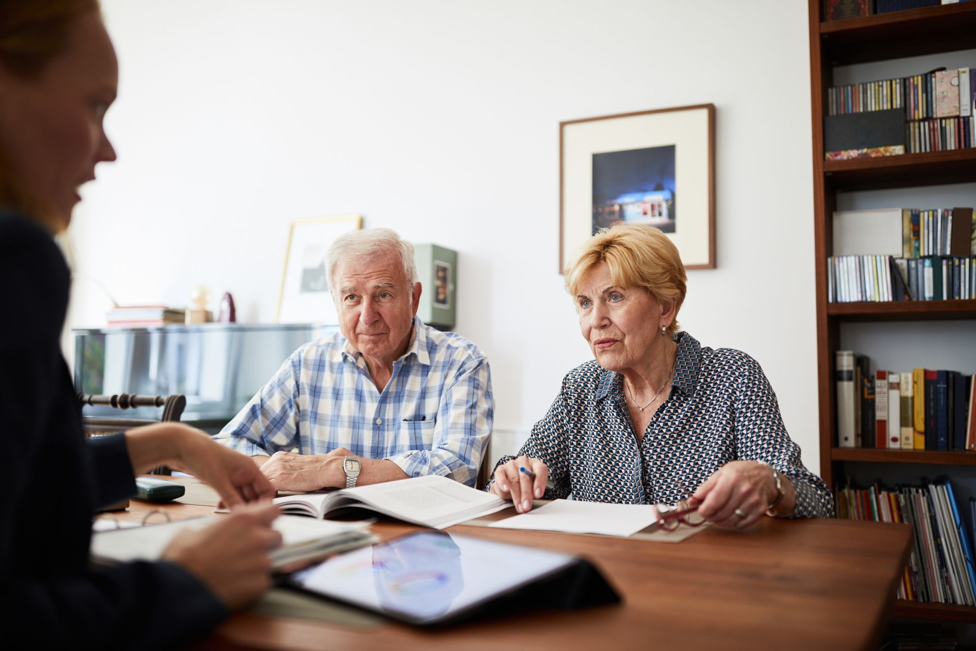 Couple listening to their female financial consultant at home.