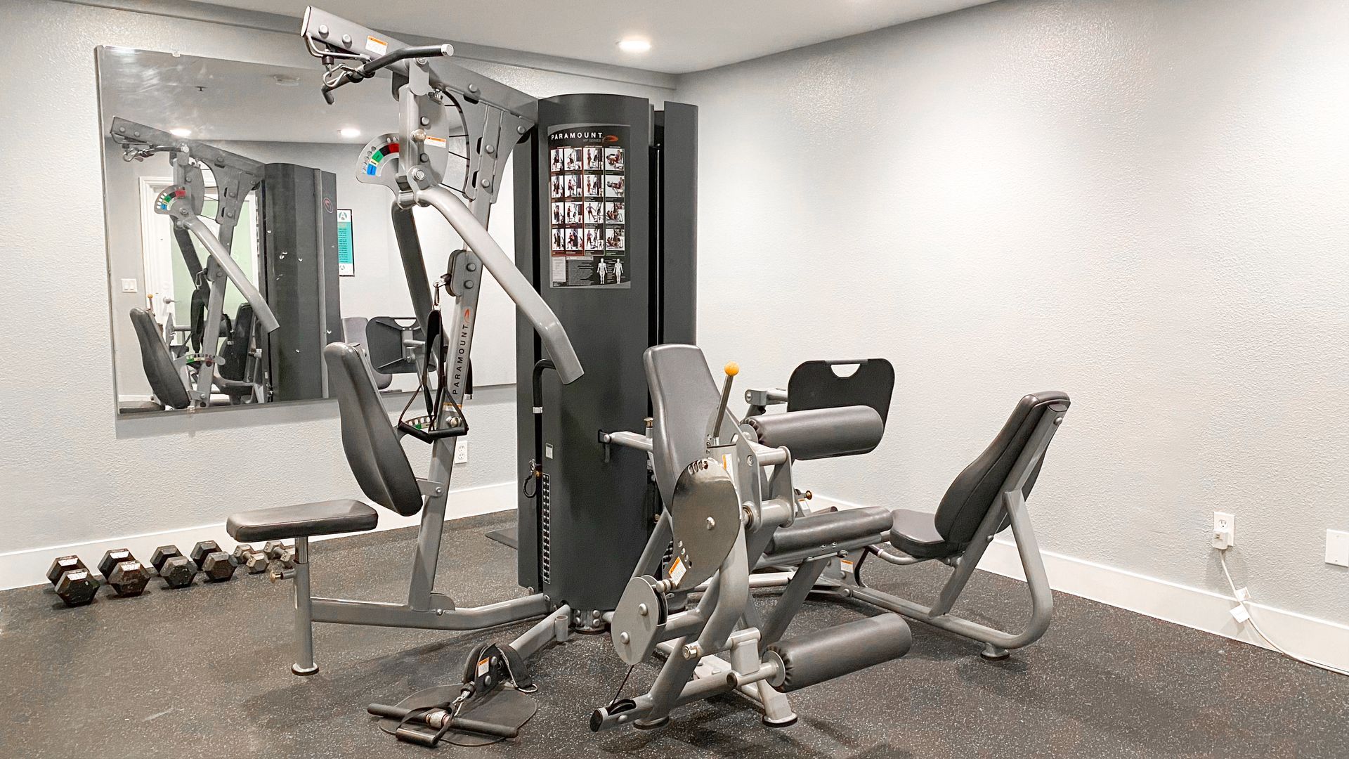 a gym with a lot of equipment and a large mirror .