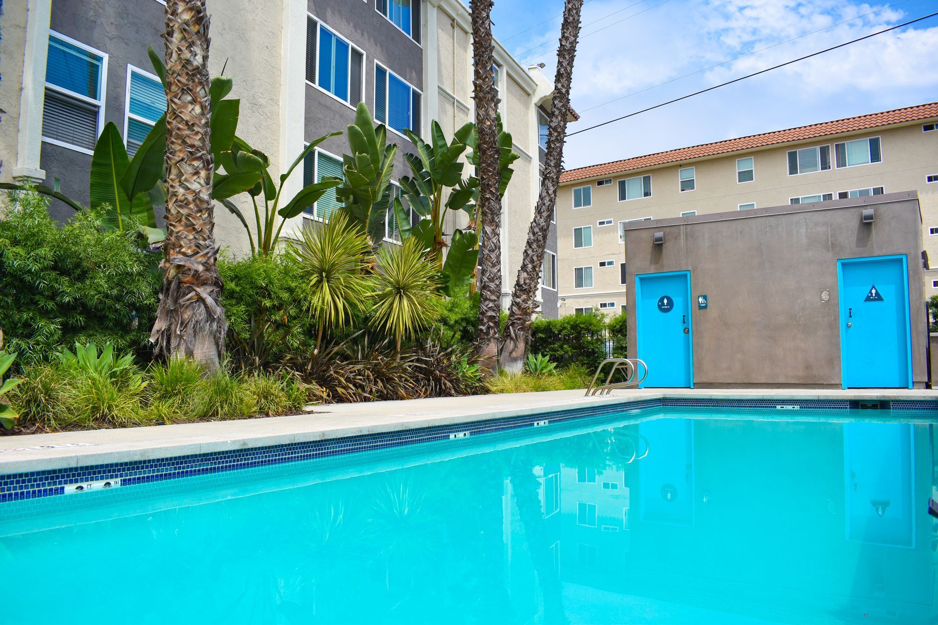 a large swimming pool with blue doors in front of a building .