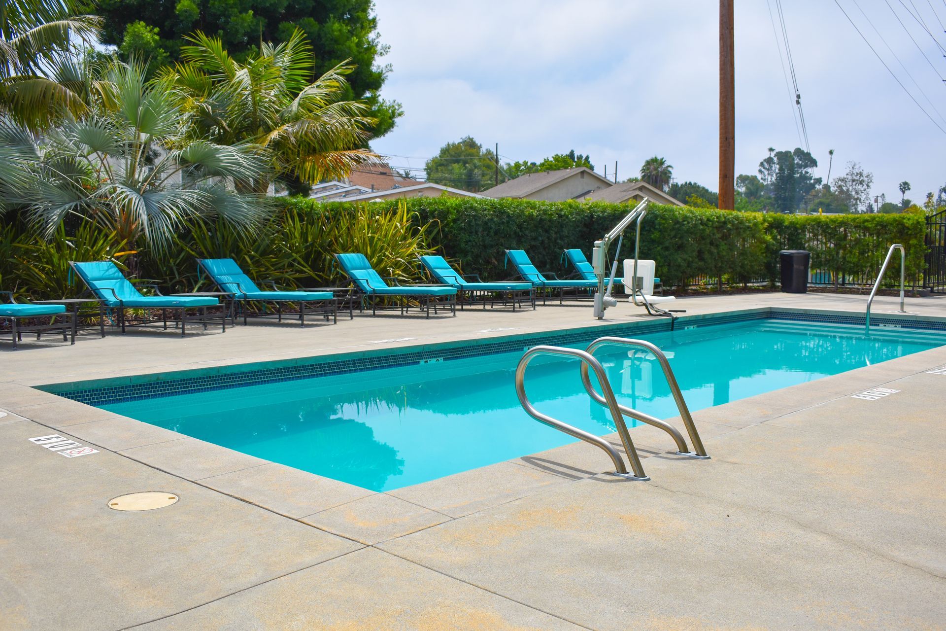 a large swimming pool with blue chairs around it