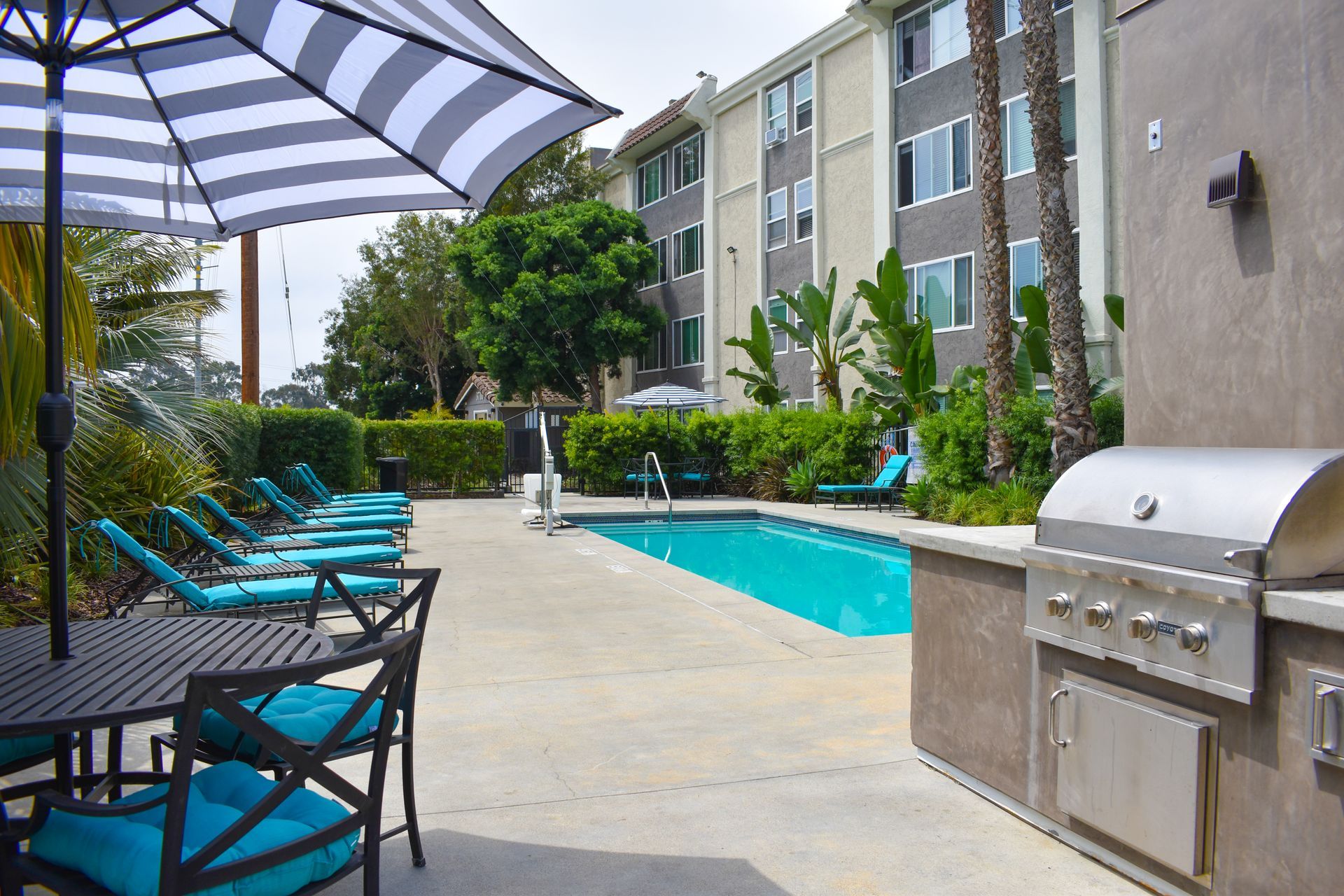 a swimming pool with tables and chairs and an umbrella