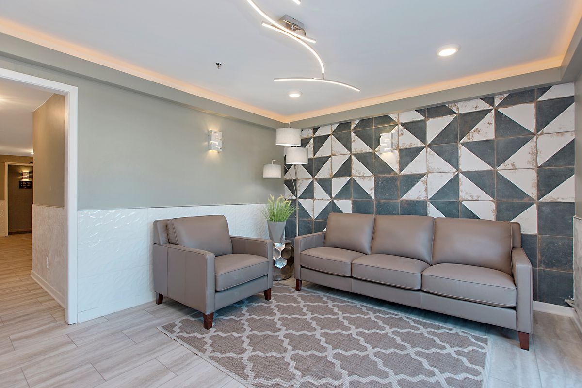 a living room with a couch , chair , and rug .