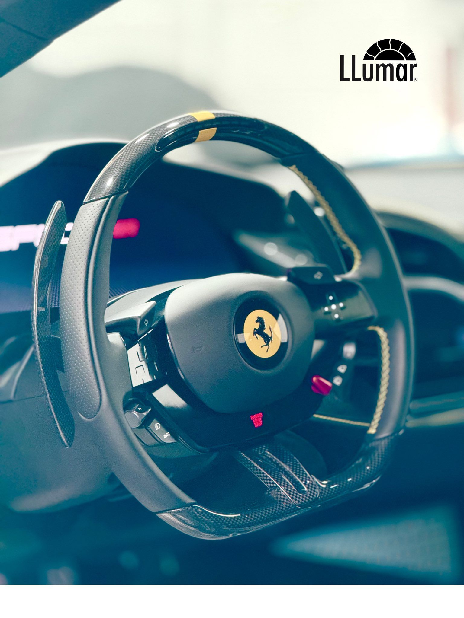 Close-up of a black Ferrari steering wheel with red accents inside a luxury car interior