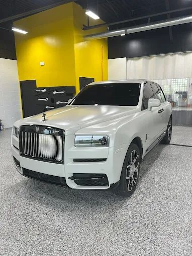 White luxury SUV in a garage with yellow walls and speckled gray floor