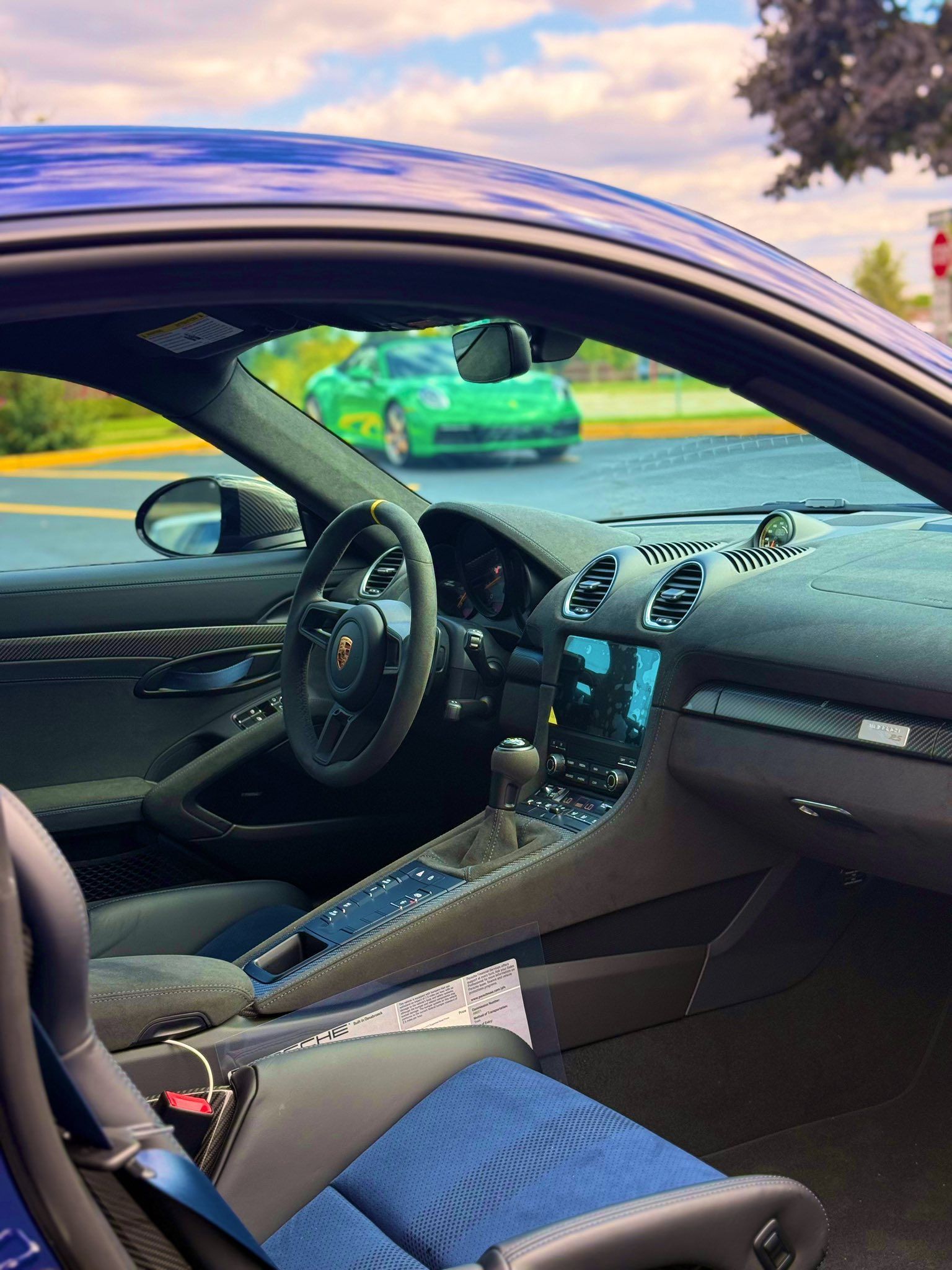 Open car interior with black seats and dashboard, viewed through the driver’s side door.