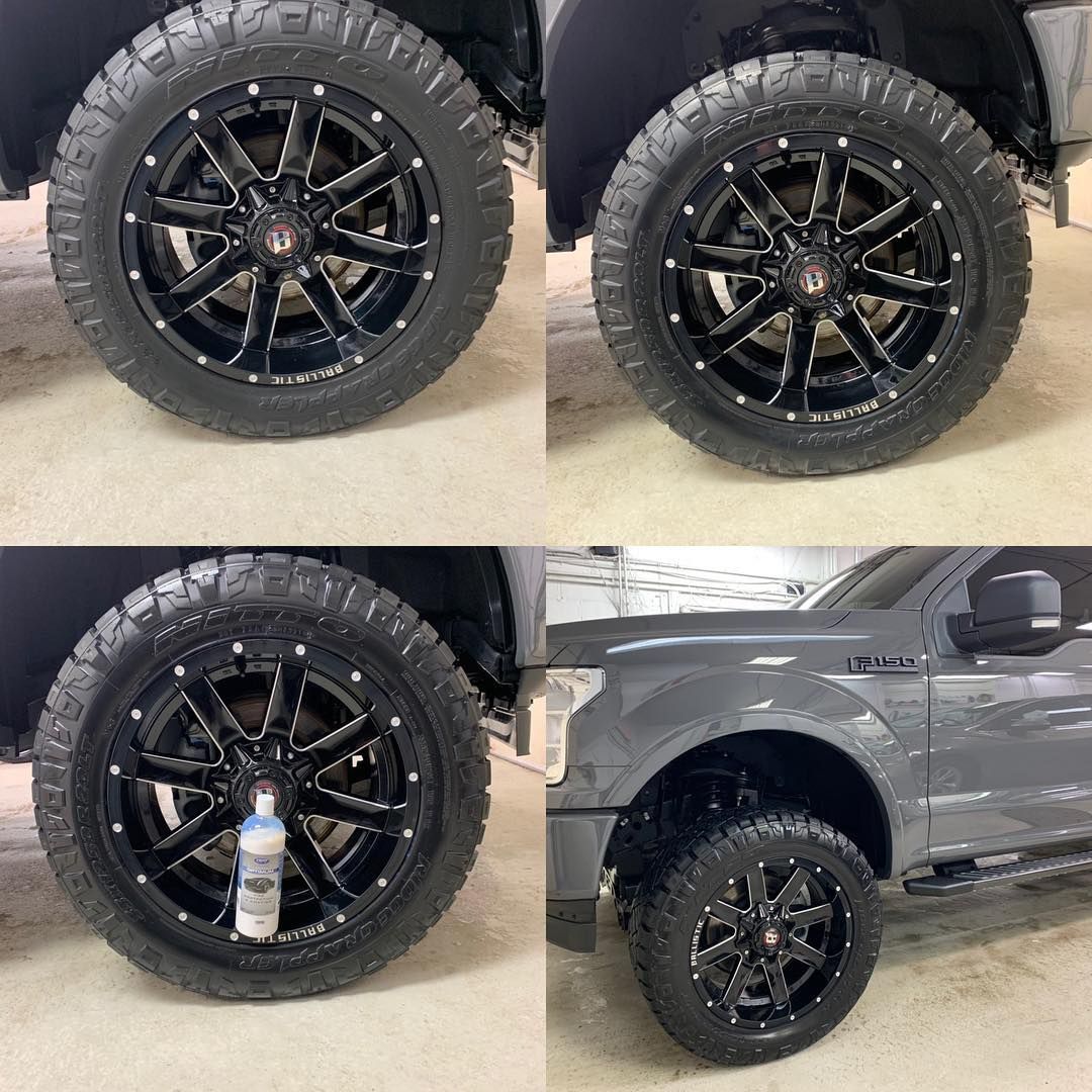 Black off-road truck wheels and tires, shown close-up on a dark pickup truck.
